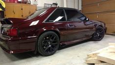 a maroon car is parked in a garage