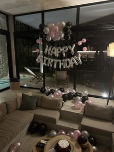 a living room filled with furniture and balloons in the shape of happy birthday written on it