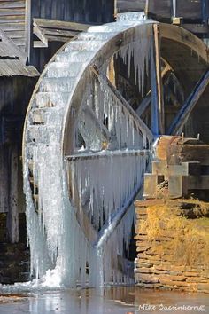 an old water wheel with icicles on it