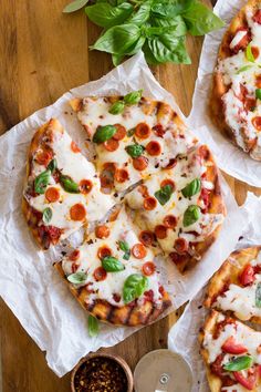 three slices of pizza sitting on top of white paper