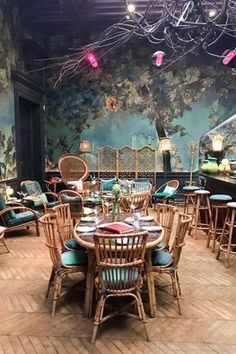 a dining room filled with lots of wooden chairs and table covered in blue cushiones