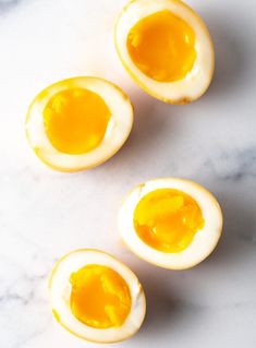 three hard boiled eggs sitting on top of a white counter next to an orange peel