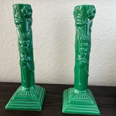 two green vases sitting on top of a wooden table