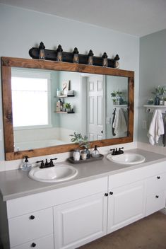 a bathroom with two sinks and a large mirror over it's counter top area