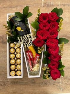 red roses and chocolates in a white box on a wooden table next to a wine bottle