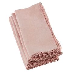 three pink towels folded on top of each other with tasseled edges and fringes