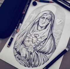 a drawing of the virgin mary holding a cross on a sheet of paper next to markers