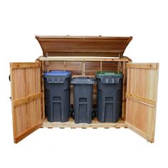 an open storage cabinet with three trash cans in it