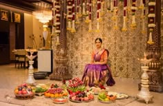 a woman sitting on the floor surrounded by food