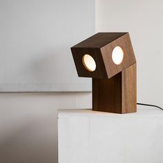 a wooden lamp sitting on top of a white block