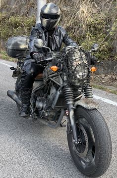 a man riding on the back of a motorcycle down a street