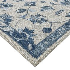 an area rug with blue and white flowers on the bottom, in front of a white background