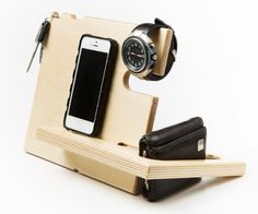 an electronic device with a cell phone and wallet on it's stand that is made out of wood