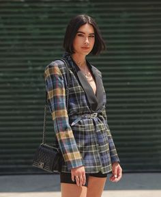 a woman with short black shorts and a plaid jacket