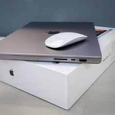 an apple laptop sitting on top of a white box with a mouse attached to it