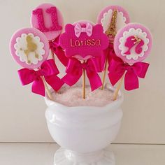 a vase filled with pink and white cupcakes