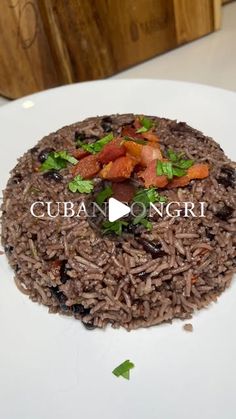 a white plate topped with rice covered in meat and veggies on top of it