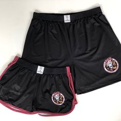 two black shorts with red trims on the bottom and one has an image of a tiger