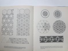 an open book with drawings and designs on the pages, including circular shapes in black ink