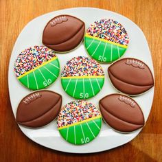 decorated cookies with footballs and sprinkles on a plate