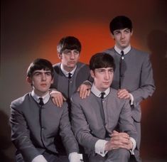 four men in suits and ties posing for a photo