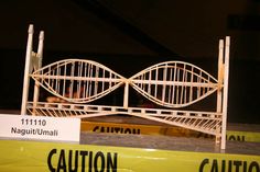 a model of a bridge with caution tape around it and a sign on the side