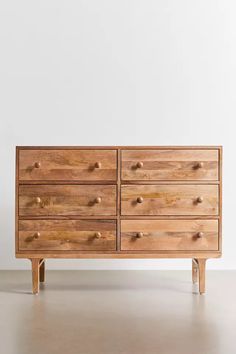 a wooden dresser sitting on top of a white floor