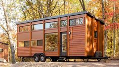 an orange tiny house sitting in the woods