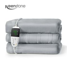 an electric blanket with thermometer attached to it and three sheets stacked on top of each other