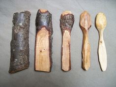 five wooden spoons are lined up next to each other