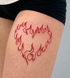 a woman's thigh with flames in the shape of a heart tattoo on it