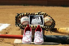 a baseball bat, glove and shoes on the ground