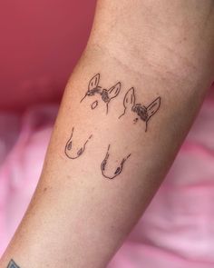 a woman's arm with three small tattoos on it