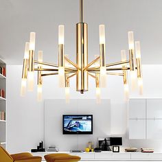 a modern chandelier hanging from the ceiling in a living room with yellow chairs