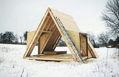 a wooden structure in the middle of a snowy field