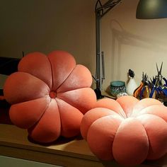 two orange flower shaped cushions sitting on top of a desk