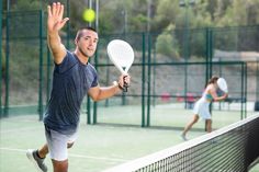 Man serving ball over net during paddleball match on outdoor court royalty free stock photography Paddle Tennis, Tennis Match, Tennis