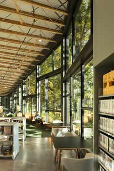 the inside of a large library with lots of bookshelves and tables in it