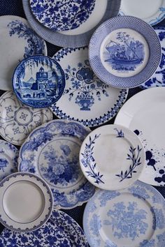 many blue and white plates stacked on top of each other