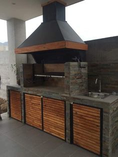 an outdoor kitchen with a grill and sink