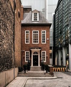 a red brick house in the middle of an alleyway with steps leading up to it