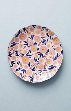 a pink and blue flowered plate on a gray surface with an arrow in the center