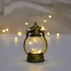 an old fashioned lantern is lit up with fairy lights