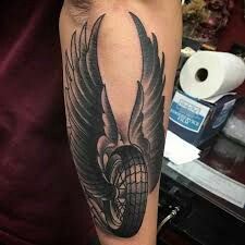 a man's arm with a black and grey tattoo design on it, featuring an eagle