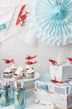 a table topped with cupcakes covered in frosting next to other dessert items