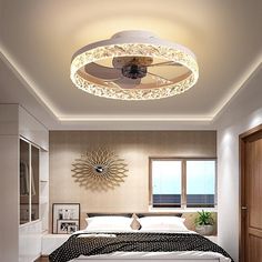 a bed room with a neatly made bed and a ceiling fan on the headboard