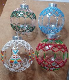 three christmas ornaments are sitting on a piece of paper with beaded decorations hanging from them