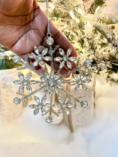 someone holding a snowflake ornament in their hand