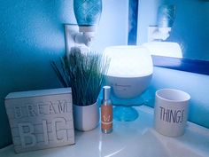 a bathroom sink with a toothbrush, cup and soap dispenser