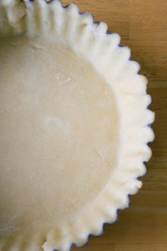 an uncooked pie crust sitting on top of a wooden table